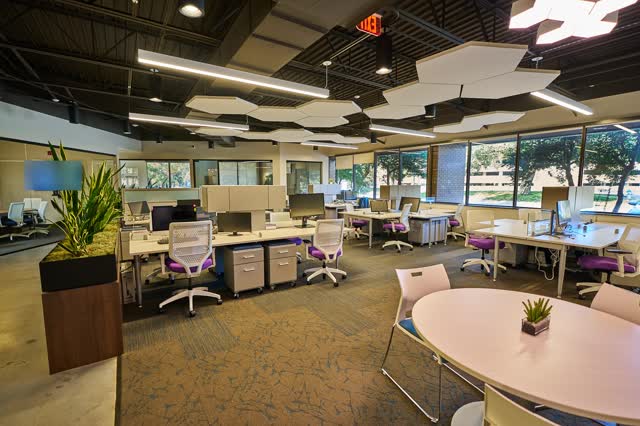 Shared desks beside floor-to-ceiling windows